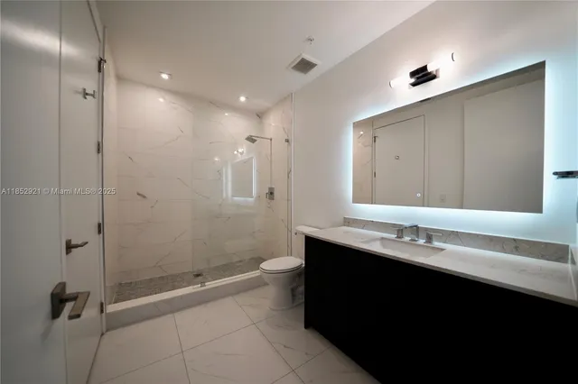 a bathroom with a double vanity sink toilet and shower