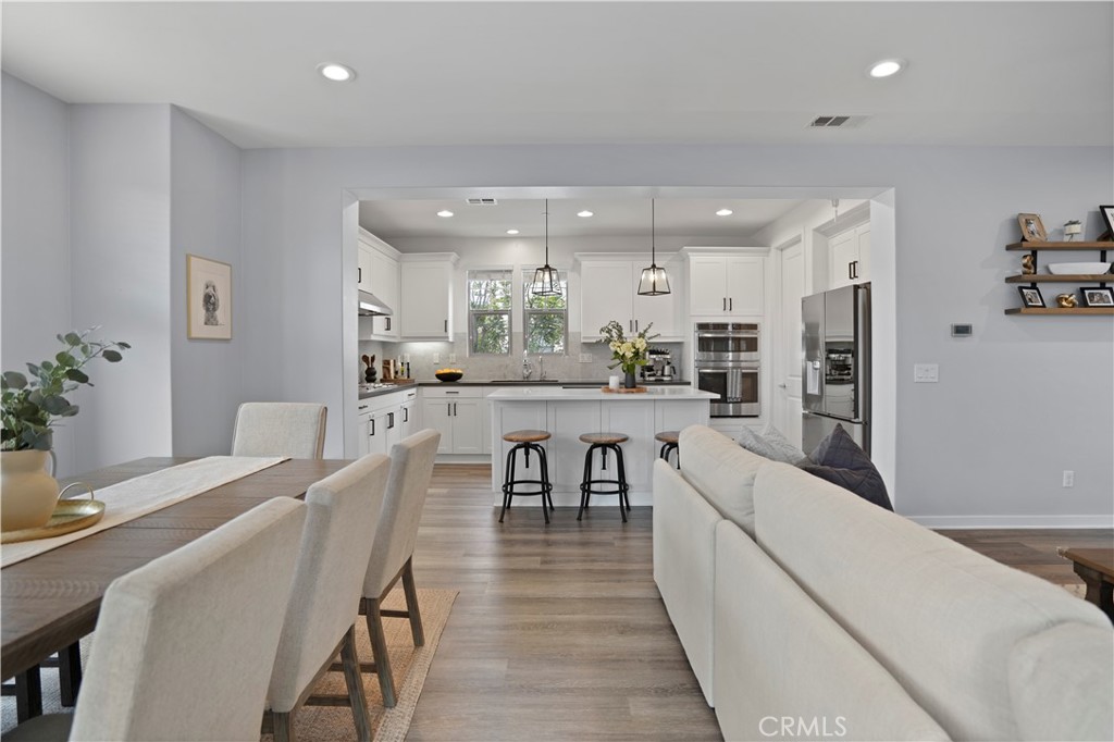 58 Vasto Street Rancho Mission Viejo, CA 92694 - Photo 11 of 66 a dining room with kitchen island stainless steel appliances furniture a chandelier and a kitchen view