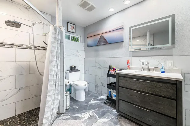 a bathroom with a sink toilet and shower
