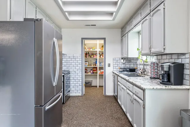 a kitchen with refrigerator and cabinets