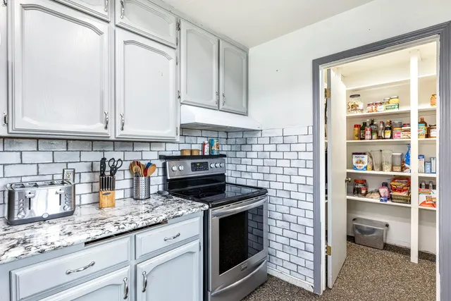 a kitchen with granite countertop white cabinets and white appliances