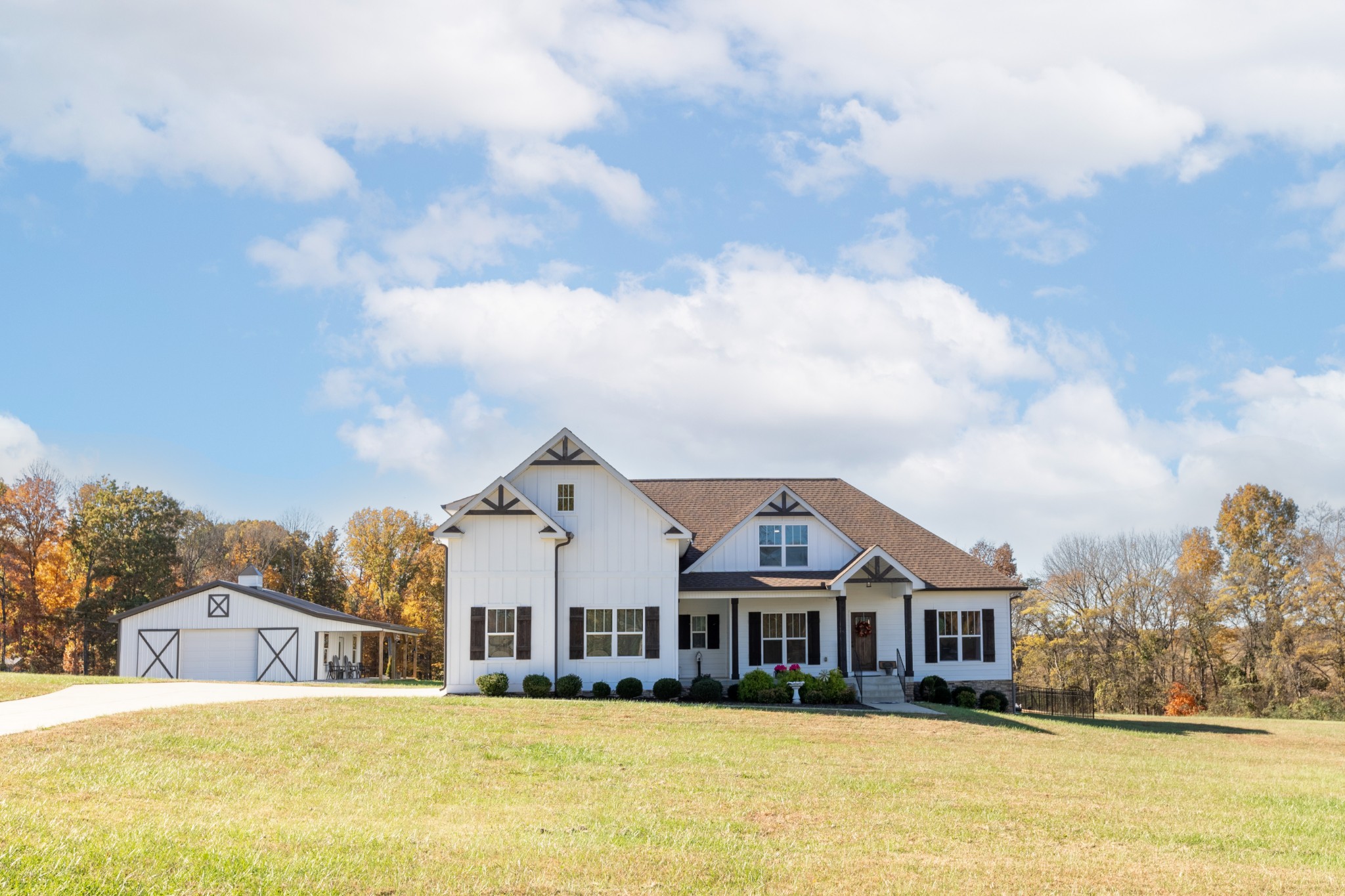 a view of a house with a big yard and large trees