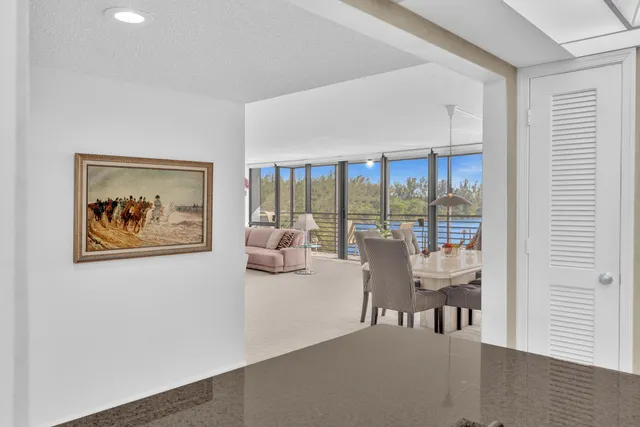 a kitchen with stainless steel appliances granite countertop a stove a refrigerator a sink dishwasher a oven with a dining table and chairs