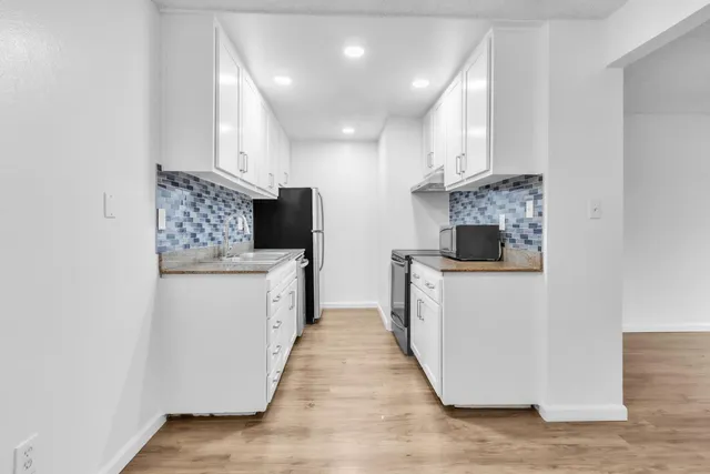 a kitchen with a refrigerator and a stove top oven