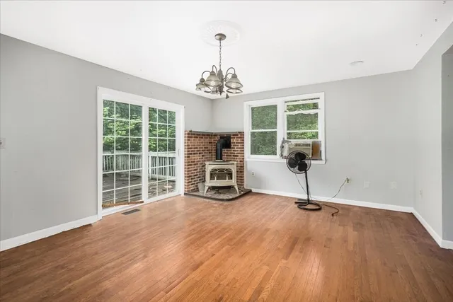 a view of a livingroom with a flat screen tv a ceiling fan and windows