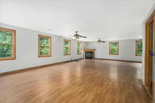 an empty room with windows and a fireplace