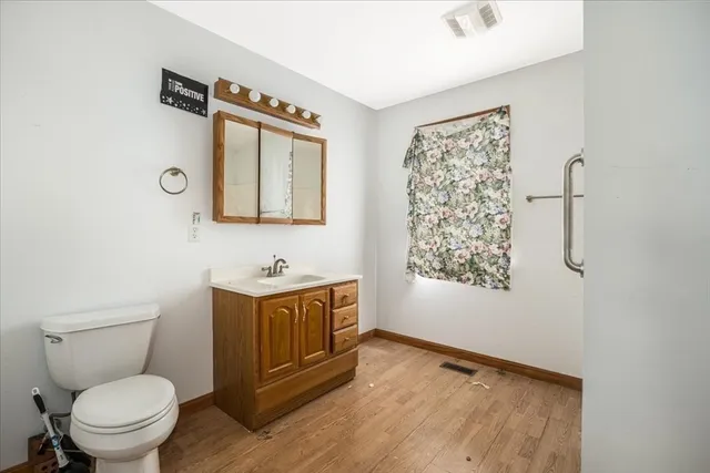 a bathroom with a toilet a sink and a mirror