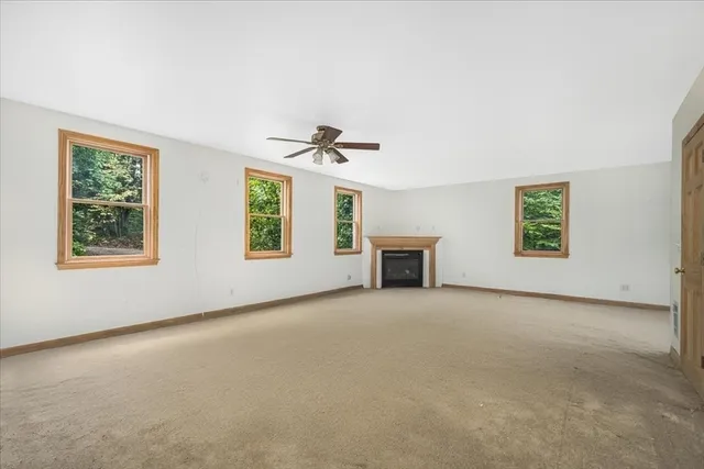 an empty room with windows and ceiling fan