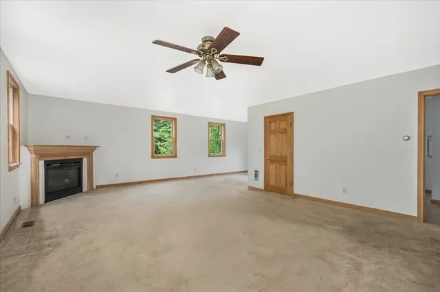 an empty room with windows and fireplace
