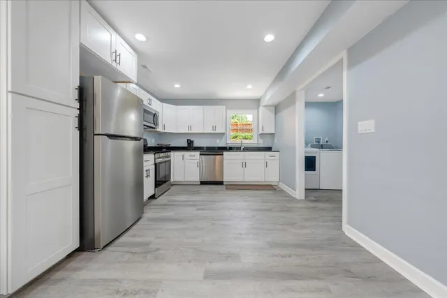a kitchen with stainless steel appliances a refrigerator sink and microwave