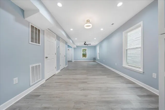 a view of a hallway with wooden floor and staircase
