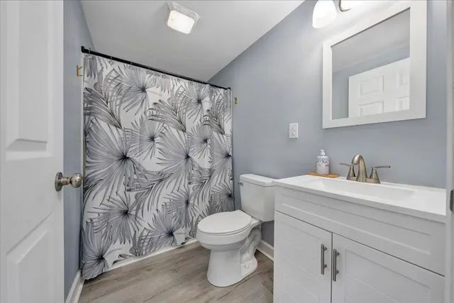 a bathroom with a granite countertop sink a toilet and a mirror