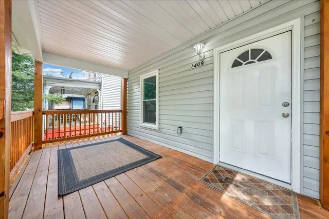a view of a porch with wooden floor and a gate