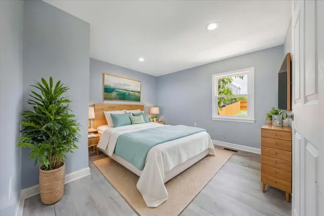a bedroom with bed and a potted plant