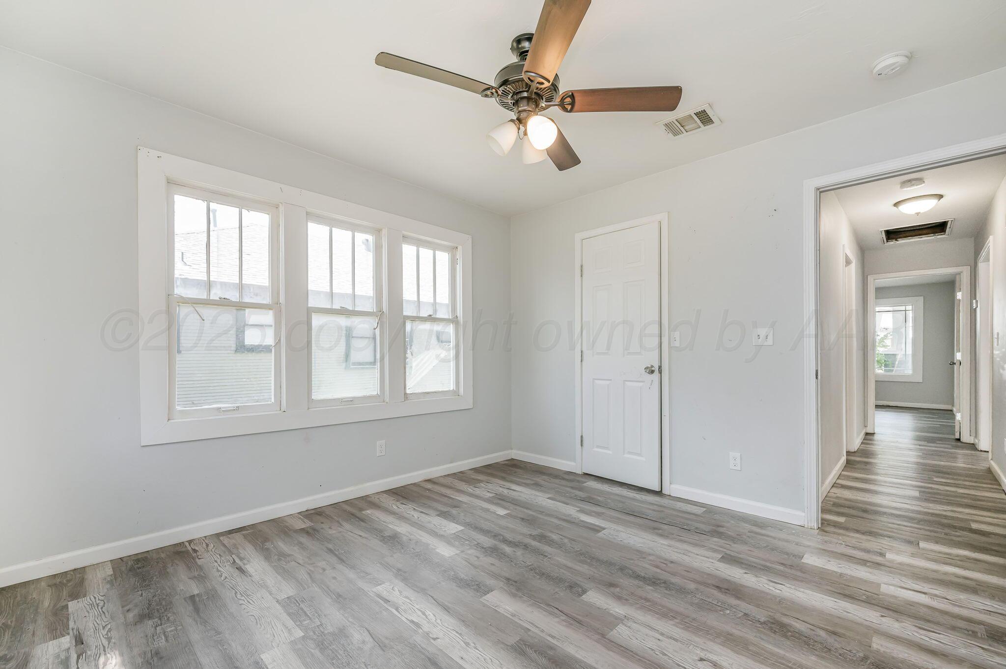 313 South Fairmont Street Amarillo, TX 79106 - Photo 12 of 15 a view of an empty room with wooden floor and a window