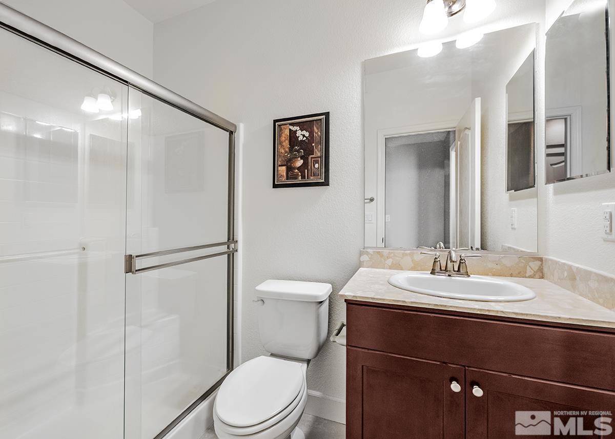 10843 Walnut Ridge Drive Reno, NV 89521 - Photo 17 of 26 a bathroom with a sink a toilet a mirror and shower