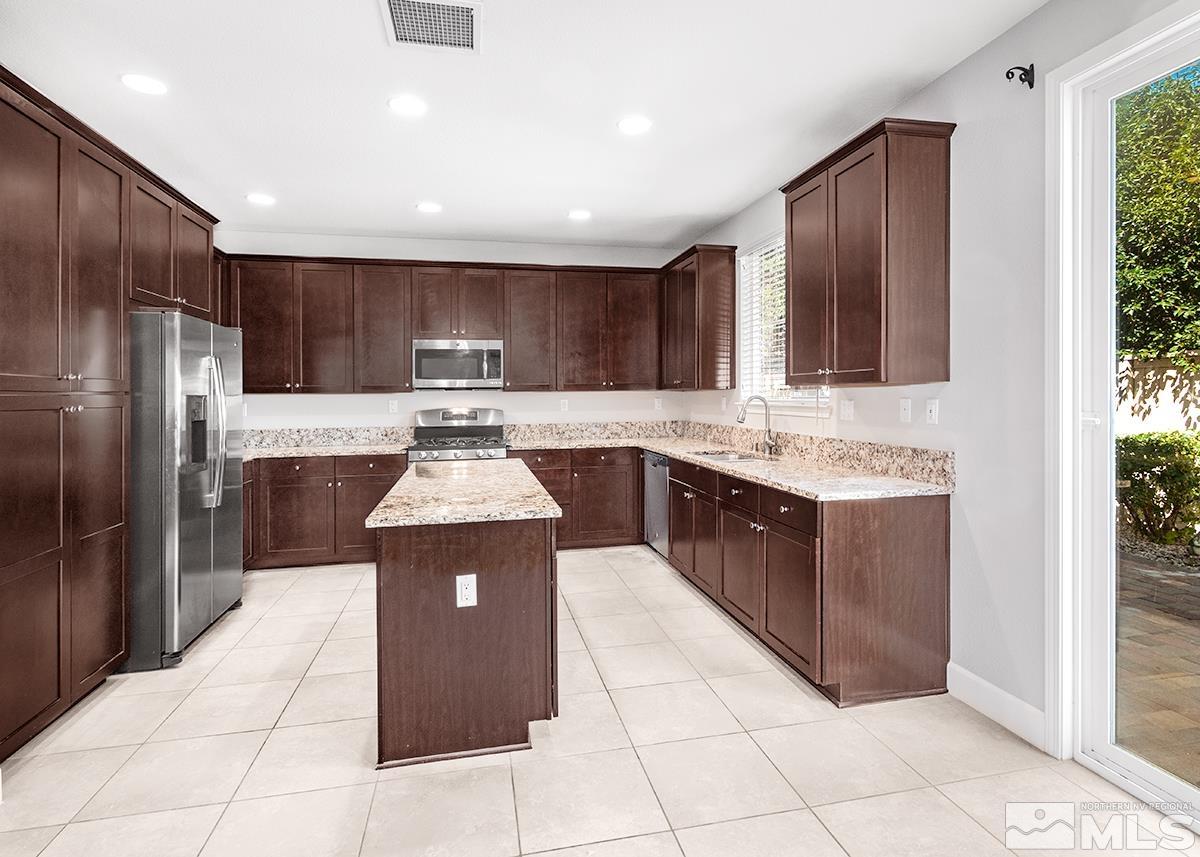 10843 Walnut Ridge Drive Reno, NV 89521 - Photo 4 of 26 a kitchen with stainless steel appliances granite countertop a stove a sink and a refrigerator