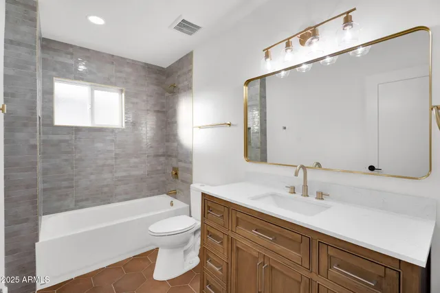 a bathroom with a toilet a sink a bathtub and a mirror