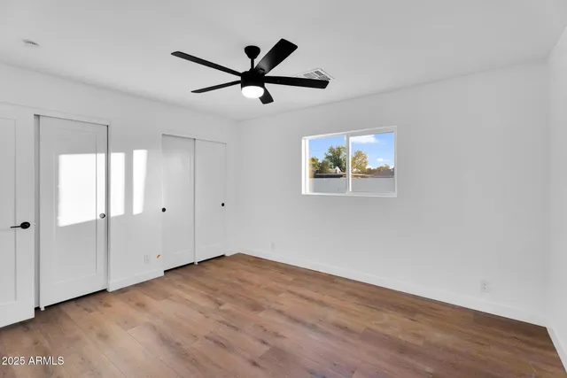 a view of empty room with wooden floor and window