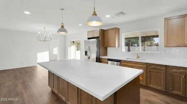 a kitchen with a stove a refrigerator a sink and chairs