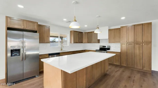 a kitchen with kitchen island a sink stove and refrigerator