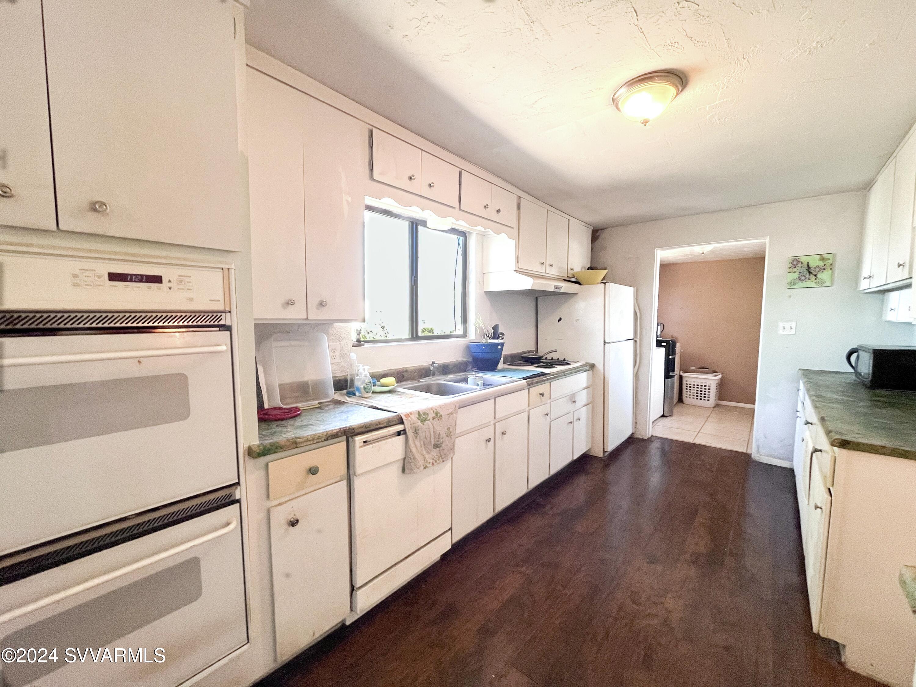 4545 North Drifting Sands Road Rimrock, AZ 86335 - Photo 19 of 52 a kitchen with granite countertop white cabinets and white appliances