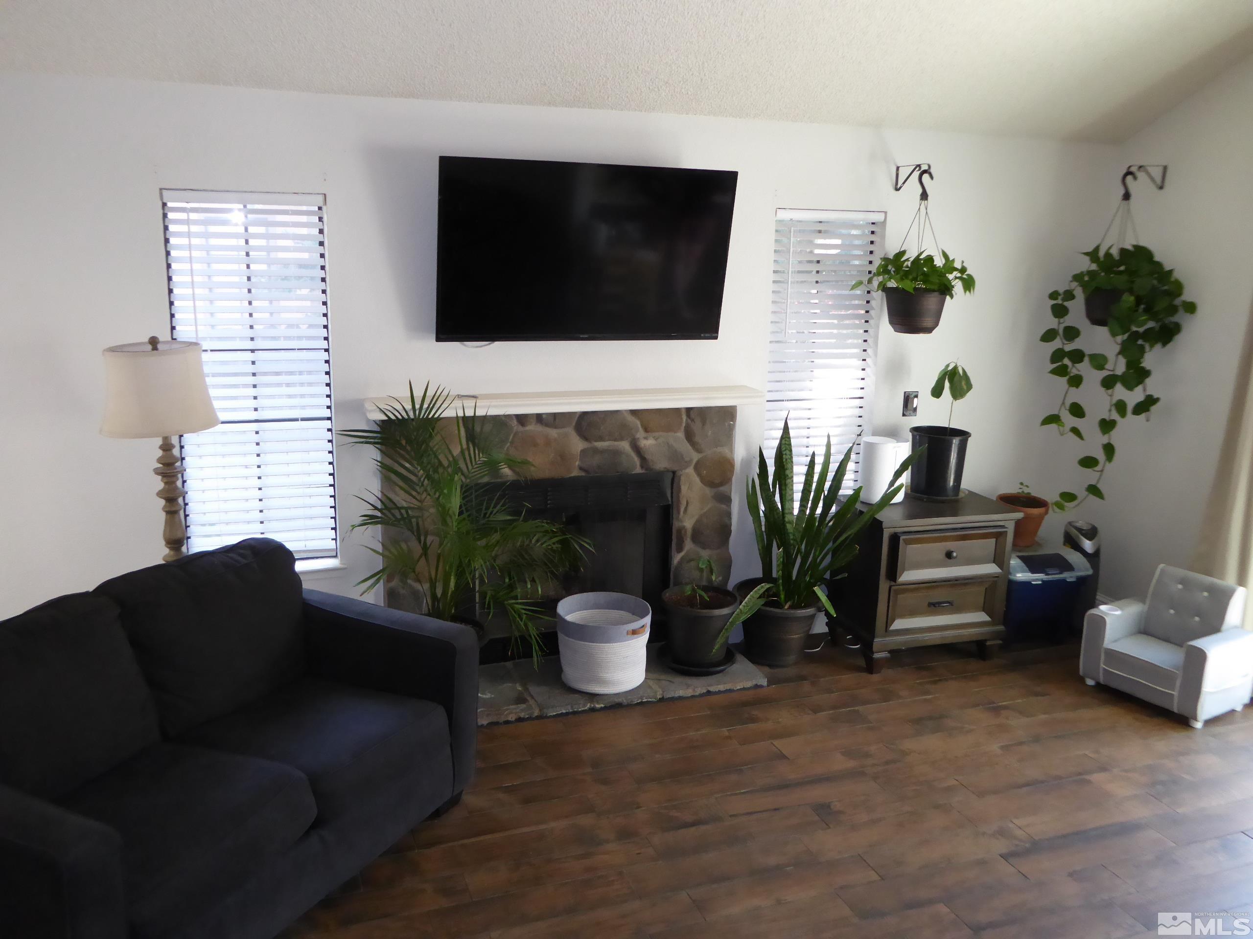 1915 Amarak Way Reno, NV 89523 - Photo 4 of 25 a living room with furniture a flat screen tv and a fireplace