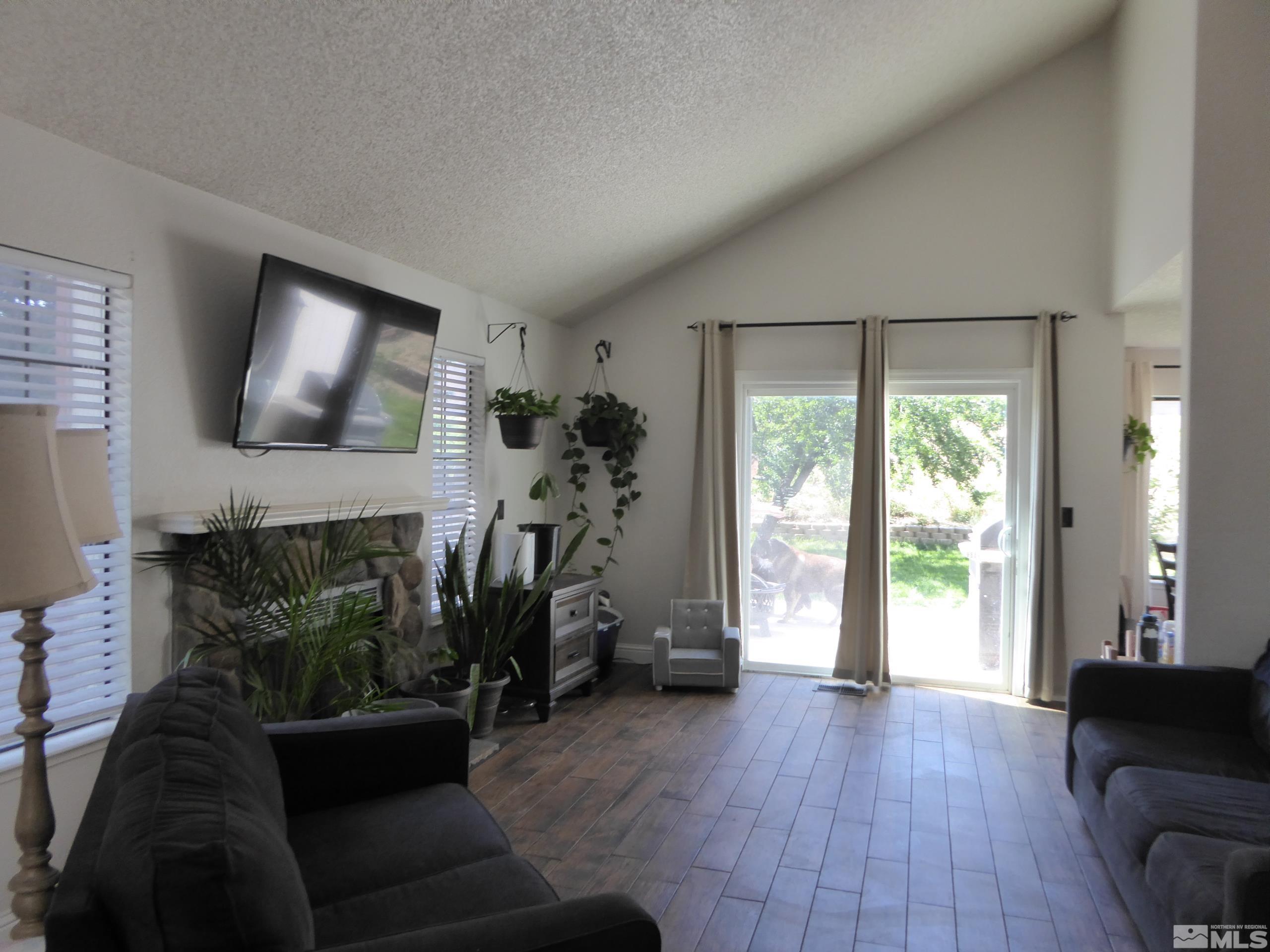 1915 Amarak Way Reno, NV 89523 - Photo 5 of 25 a living room with furniture a flat screen tv and a floor to ceiling window