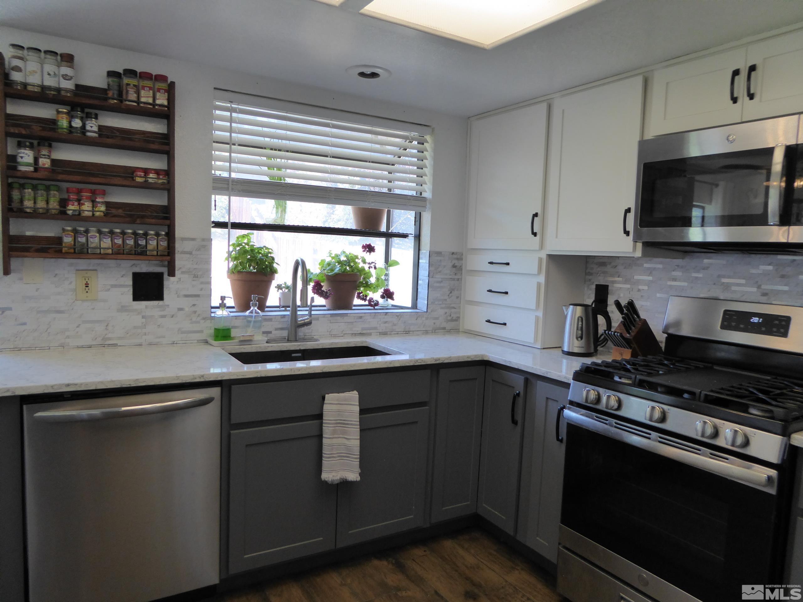 1915 Amarak Way Reno, NV 89523 - Photo 7 of 25 a kitchen with stainless steel appliances a stove a sink and a microwave