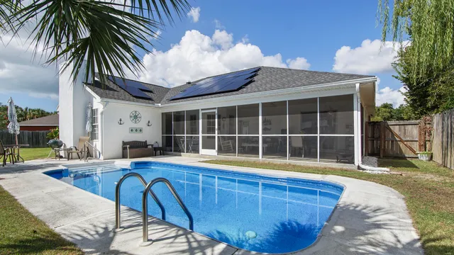 a view of a house with swimming pool and sitting area