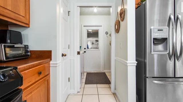 a view of a kitchen from the hallway with a refrigerator