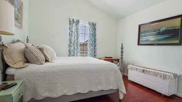 a bedroom with a bed and a painting on the wall