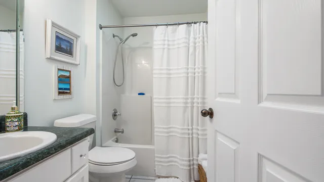 a bathroom with a granite countertop sink toilet and shower
