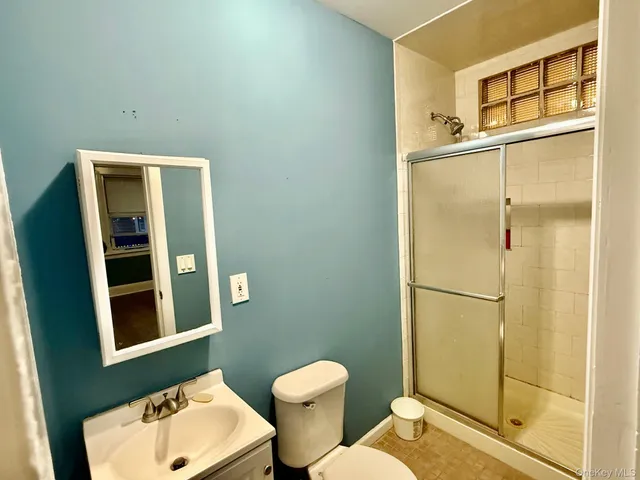 a bathroom with a toilet sink shower and a mirror