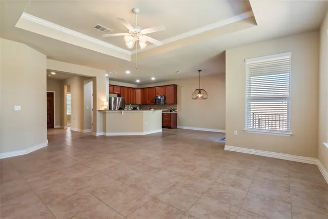 a view of a livingroom with furniture a kitchen view and a window