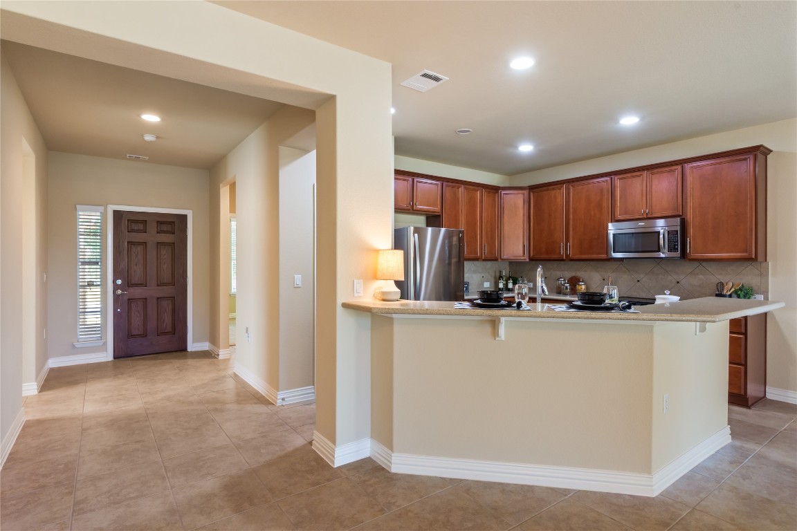 106 Trinity Lane Georgetown, TX 78633 - Photo 8 of 24 a kitchen with stainless steel appliances granite countertop a refrigerator and a stove top oven