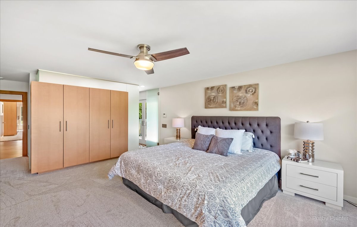 589 Plum Tree Road Barrington Hills, IL 60010 - Photo 22 of 46 a bedroom with a large bed and a chandelier