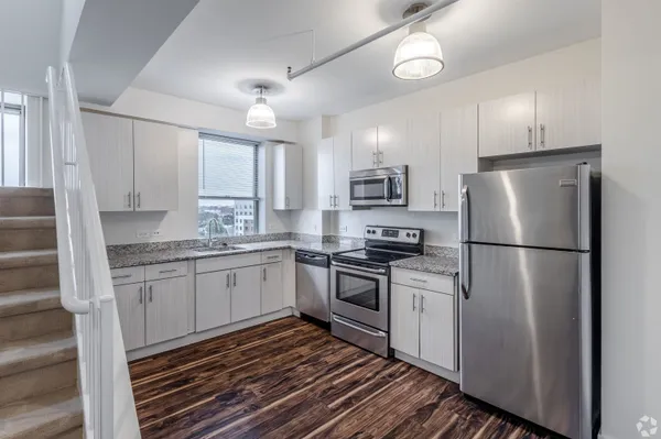 a kitchen with a refrigerator a sink and cabinets