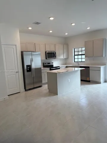 a kitchen with refrigerator and cabinets