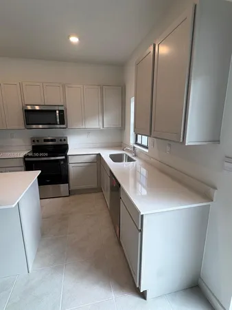 a kitchen with stainless steel appliances granite countertop a sink a stove a microwave a sink a refrigerator and cabinets