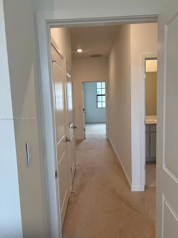 a view of a hallway with a livingroom and a bathroom