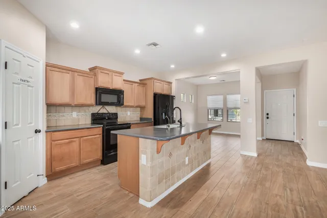 a kitchen with stainless steel appliances kitchen island granite countertop a stove and a sink