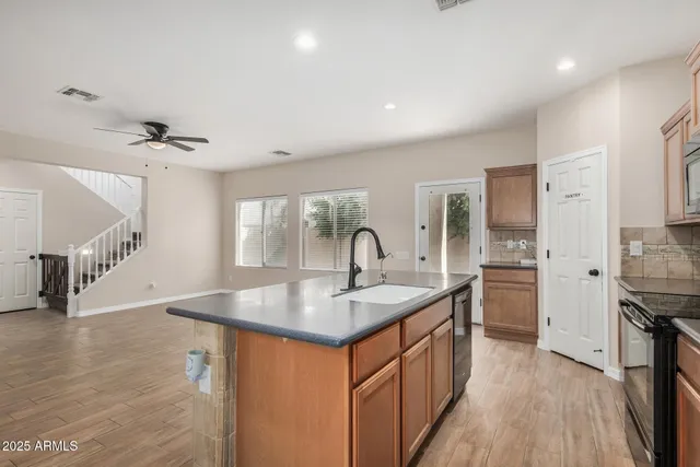 a kitchen with stainless steel appliances granite countertop a sink stove and refrigerator