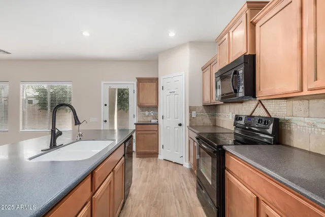a kitchen with a sink a stove and cabinets