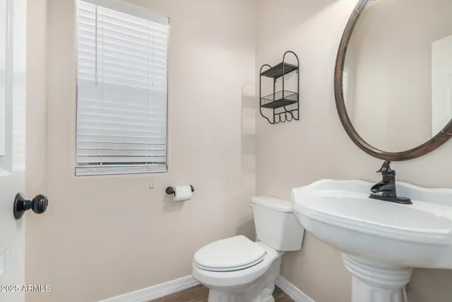 a bathroom with a sink a toilet and a mirror