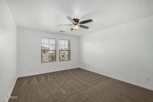 an empty room with a window and a fan