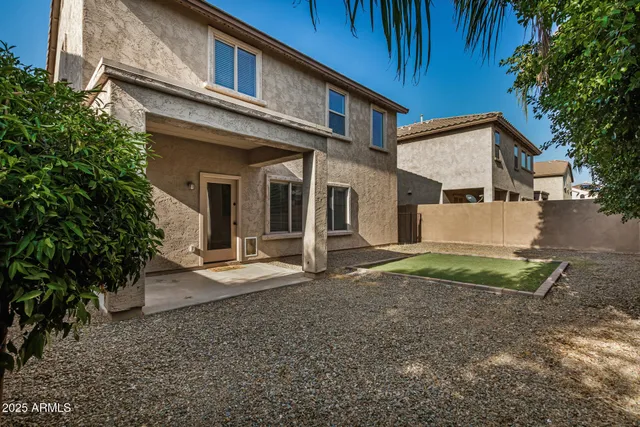 a view of a house with a yard and large tree