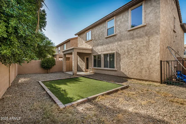 a view of a house with backyard and sitting area