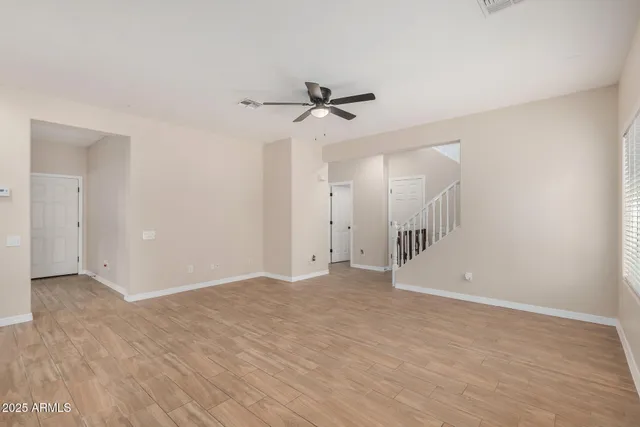 a view of an empty room with a ceiling fan