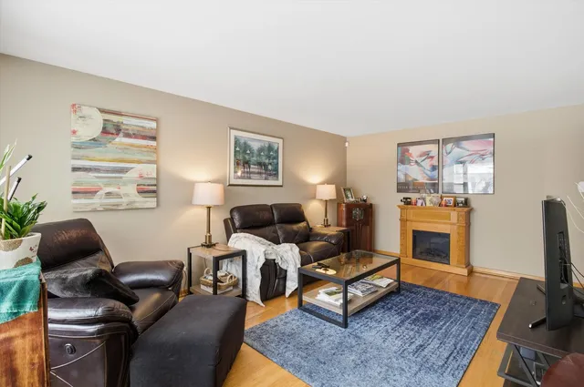 a living room with furniture a flat screen tv and a fireplace